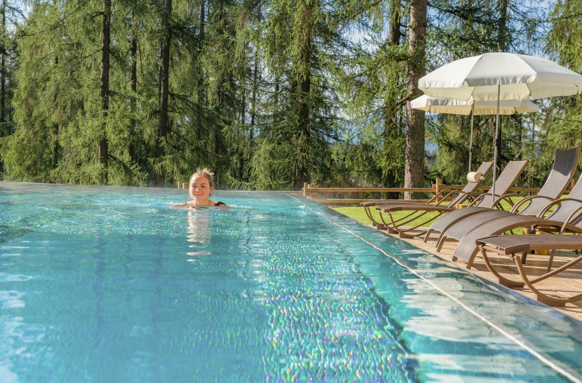The lady swims in the outdoor pool of the Hotel Lindenhof in Ramsau am Dachstein, Styria during her summer holiday.