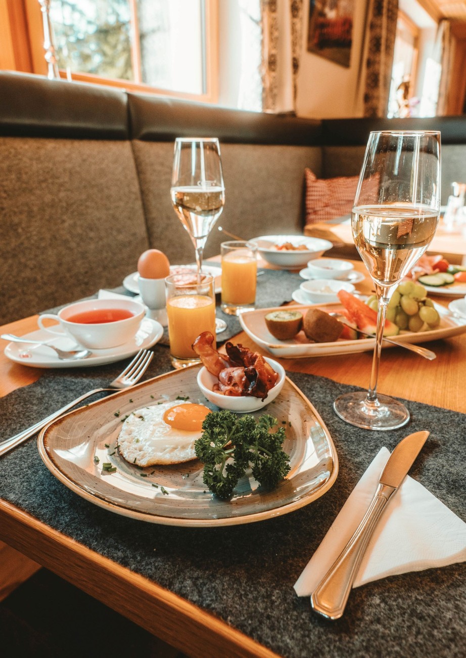 Breakfast plate with eggs and wine in front of a window with a view at the Lindenhof