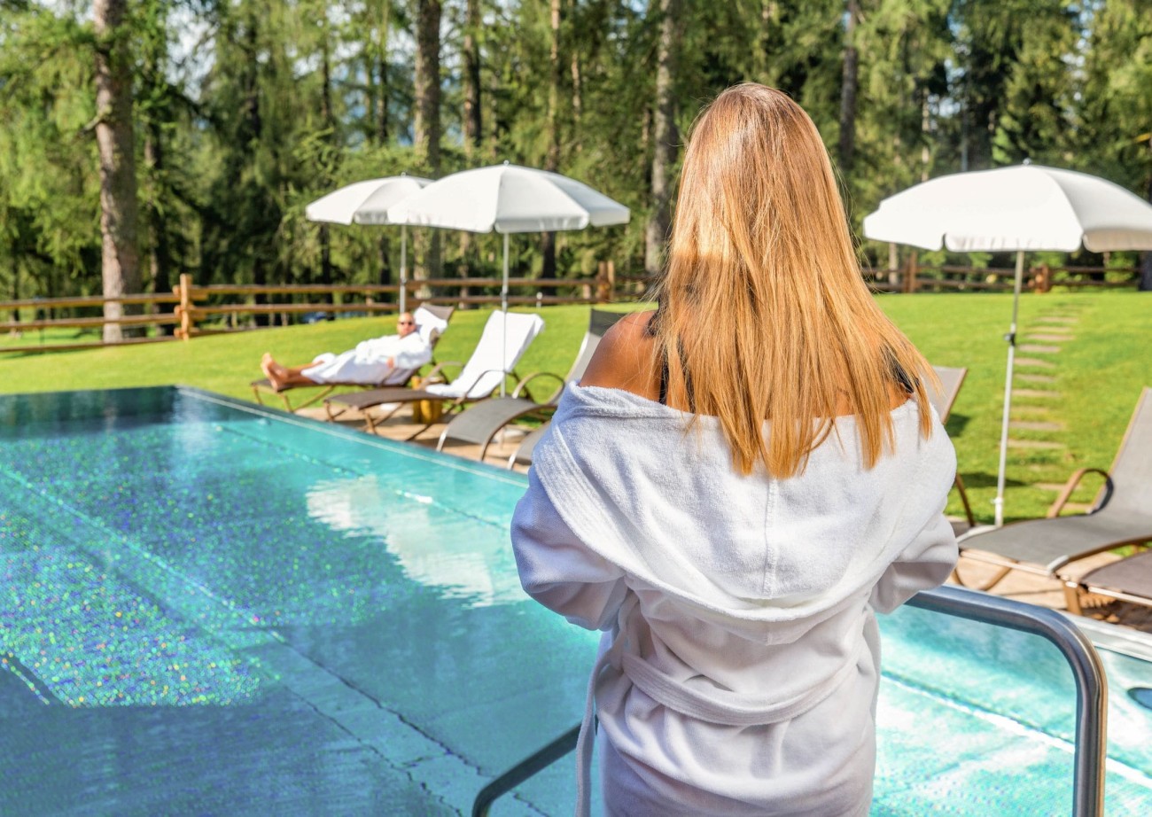Woman in a bathrobe looks at the Lindenhof's outdoor pool area