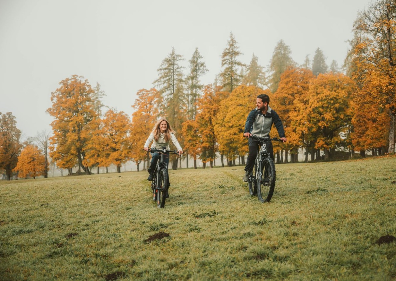 Hotelgäste fahren Fahrrad auf einer Wiese nahe dem Hotel