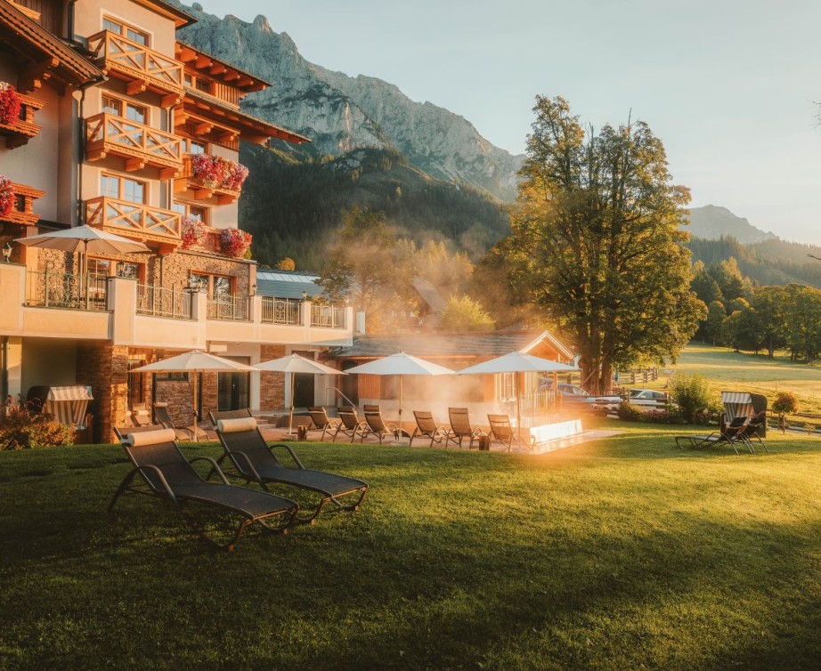 Hotel Lindenhof in Ramsau am Dachstein im Herbst mit golden gef&auml;rbten L&auml;rchen vor dem Dachsteinmassiv