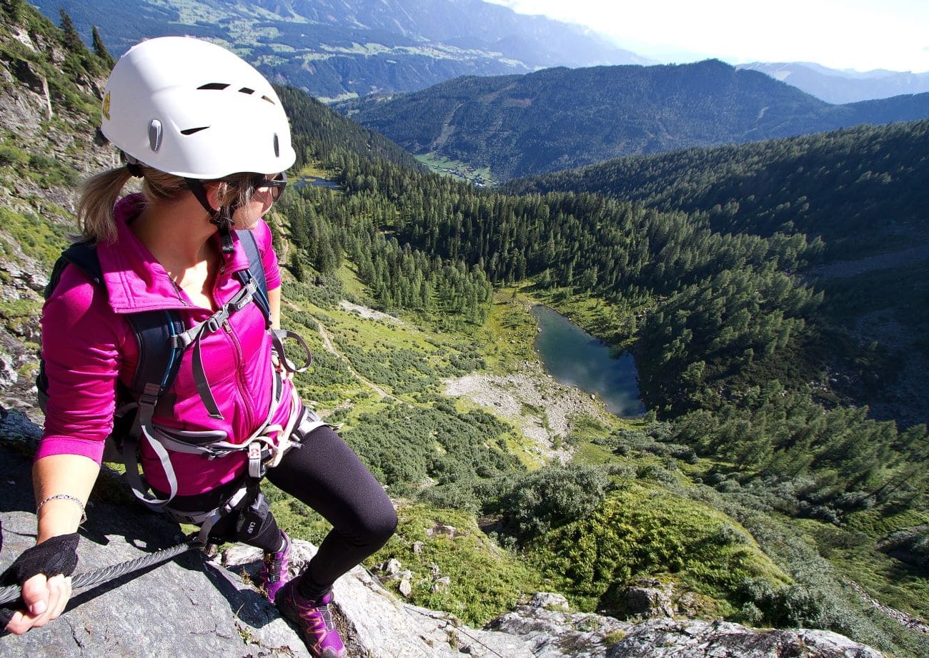 Kletterin blickt auf Bergsee