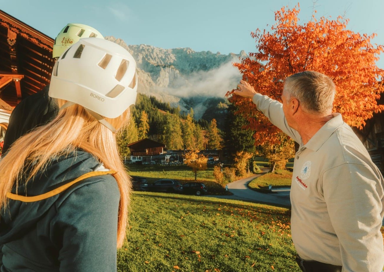 Bergführer von Hotel Lindenhof zeigt auf Gipfel und beratet 
