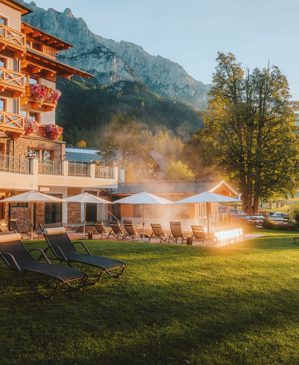 Hotel Lindenhof in Ramsau am Dachstein offers breathtaking views of the surrounding mountains and invites guests to relax on the lawn