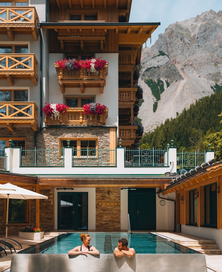 Beheizter Infinity-Pool im Hotel Lindenhof mit Blick auf das herbstliche Dachsteinmassiv