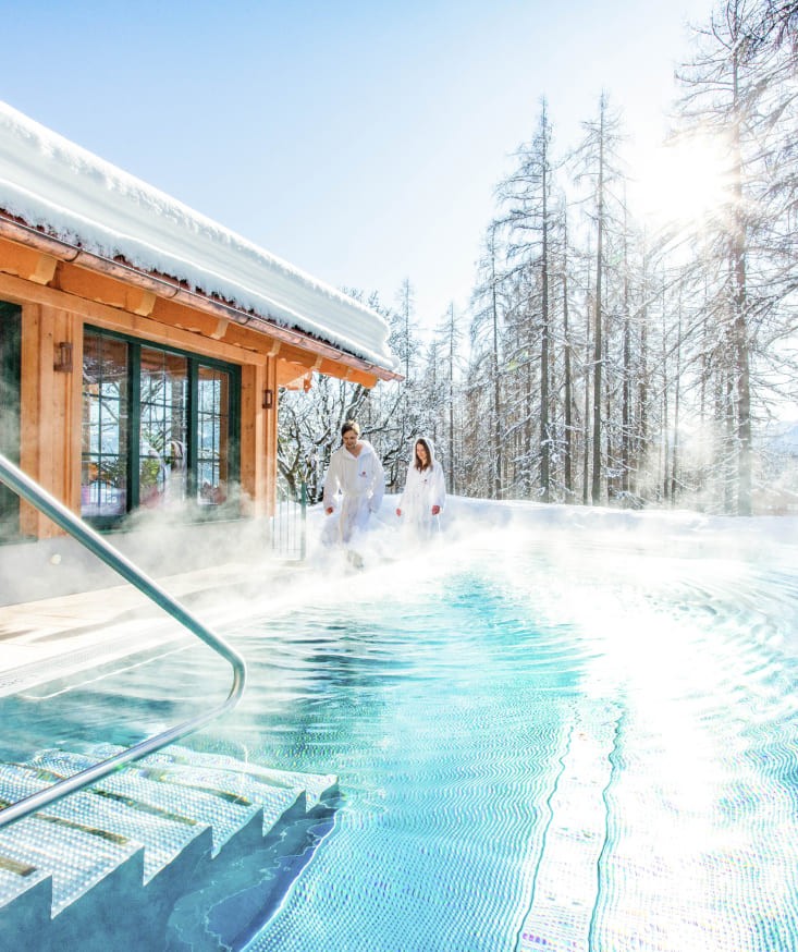 Dive into the heated infinity pool with mountain views in winter