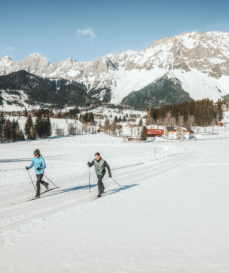 Two people cross-country skiing on the Sonnenloipe trail in Ramsau