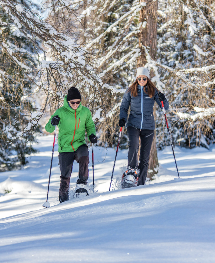 Couple starts a winter hike with snowshoes near the Hotel Lindenhof.