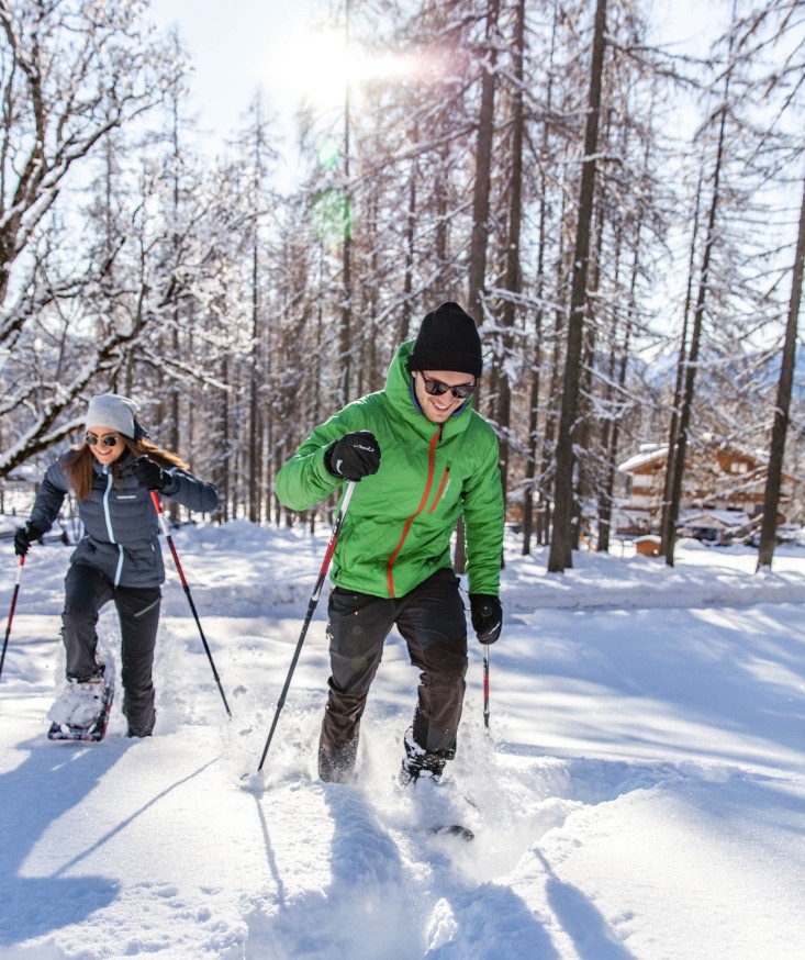 Snowshoeing through a snowy forest directly from the Hotel Lindenhof.